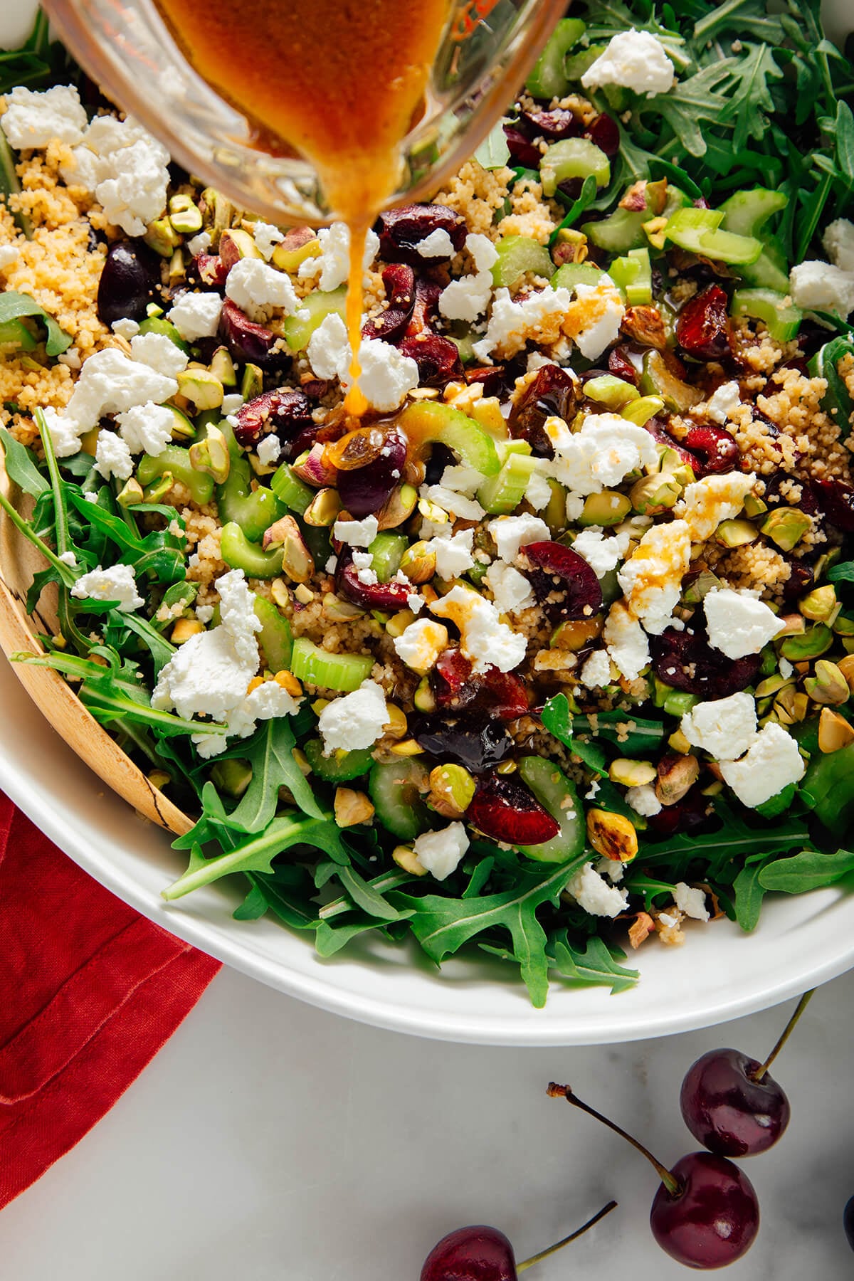 drizzling dressing over salad